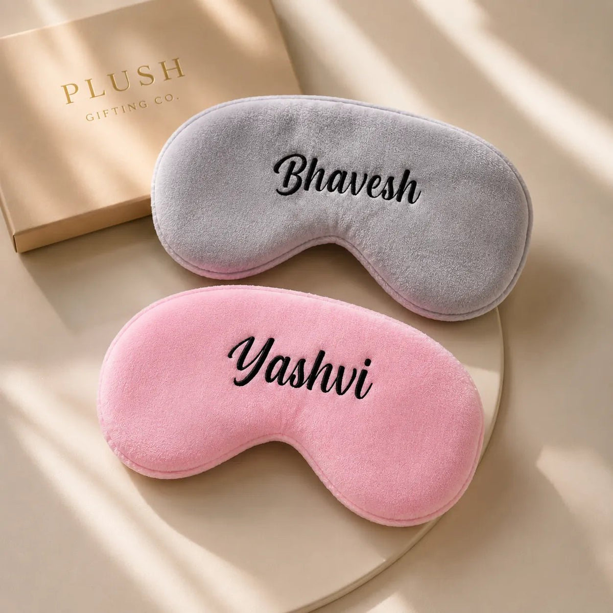 Personalized plush eye mask customized with custom name in pink and grey colours.