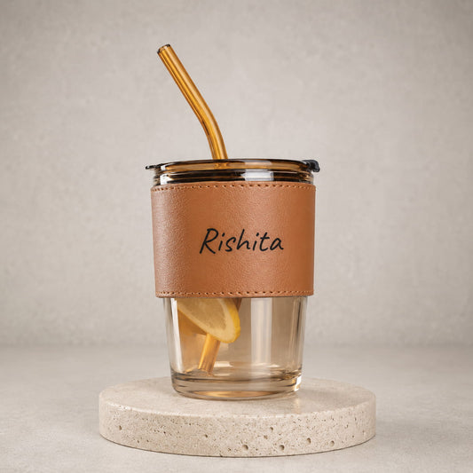 Personalized glass sipper tumbler with leather sleeve, reusable straw and custom name printing.